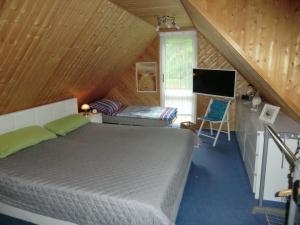 a bedroom with a bed and a television in a attic at Ferienhaus Zingst MinHus in Zingst +2 photos