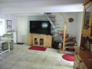 a living room with a staircase and a large screen tv at Ferienhaus Zingst MinHus in Zingst
