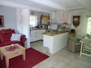 a living room with a red couch and a kitchen at Ferienhaus Zingst MinHus in Zingst