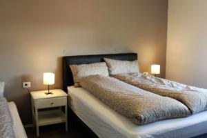 a bedroom with a bed with two lamps on it at Grímsstaðir holiday home - Family friendly in Reykholt