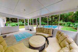 a living room with a couch and chairs and a pool at The Saltwater Cottage in Jacksonville