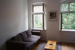 a living room with a couch and two windows at Room in the center of Berlin in Berlin