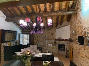 a living room with a stone wall and a chandelier at La Cabaña 