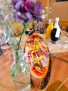 Un sándwich con jamón y verduras en un jarrón sobre una mesa. en Die Schlickeralm, en Telfes im Stubai