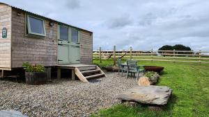uma pequena casa com uma mesa e um banco em Shepherds Delight em Werrington