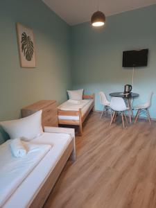 a room with two beds and a table and a tv at U Józefa in Tychy