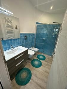 bagno con lavandino, servizi igienici e specchio di Villa San Leo a San Leone