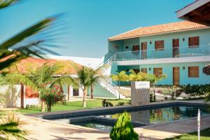 um edifício com piscina em frente a um edifício em Pousada Maanain em Icapuí