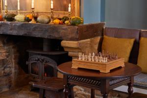 a chess board on a table in front of a fireplace at The Queens Arms in Sherborne +37 photos