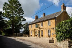 an old brick building on the side of a road at The Queens Arms in Sherborne