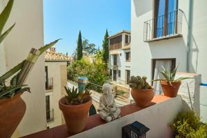 a balcony with potted plants and a statue on a ledge at Casa el "Tablao de las Almendras" in Granada