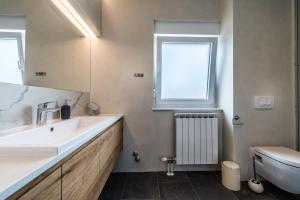 a bathroom with a sink and a toilet and a window at The Park Apartment in Zadar