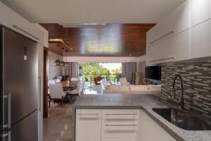 a kitchen with a sink and a living room at Romantic getaway next to the beach in Cancún