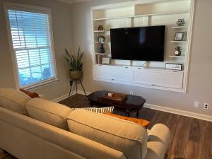 sala de estar con sofá y TV de pantalla plana en The Blue Dog House, en Lafayette