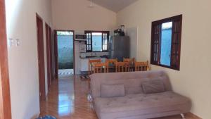 a living room with a couch and a kitchen at Lar doce lar em Paraty in Paraty