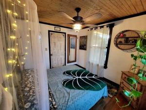 a bedroom with a bed and a ceiling fan at Cozy AF Jungle-House Hideaway in Tampa