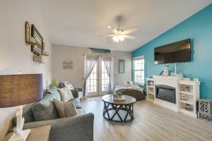 a living room with a couch and a tv at Gulf Shores Condo with Pool Access, 5 Mi to Beach! in Gulf Shores