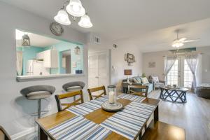 een eetkamer en een woonkamer met een tafel en stoelen bij Gulf Shores Condo with Pool Access, 5 Mi to Beach! in Gulf Shores