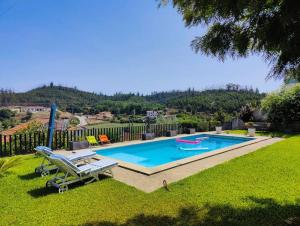 a swimming pool in a yard next to a fence at Casa dos Arcos in Oliveira de Frades