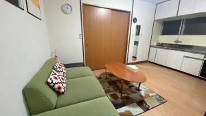 a living room with a green couch and a table at Takamatsu-205 in Takamatsu