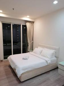 Cama blanca en habitación con ventana en One Bukit Ceylon Hosted by TCL Home 9062 en Kuala Lumpur