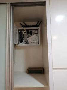 um armário com uma prateleira com uma fotografia e uma caixa em One Bukit Ceylon Hosted by TCL Home 9062 em Kuala Lumpur