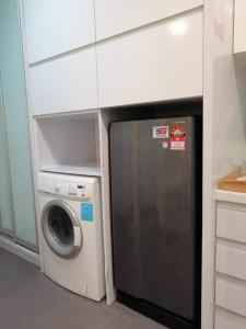 uma cozinha com um micro-ondas e uma máquina de lavar e secar roupa em One Bukit Ceylon Hosted by TCL Home 9062 em Kuala Lumpur