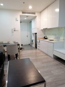 a kitchen with white cabinets and a table in it at One Bukit Ceylon Hosted by TCL Home 9062 in Kuala Lumpur