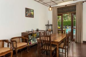 comedor con mesa de madera y sillas en Surveyor's Residence Bungalow en Kandy