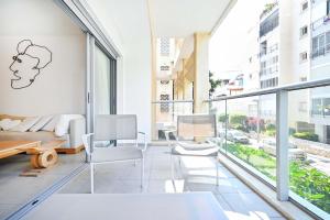 a living room with white furniture and large windows at Tiramisu for two by HolyGuest in Tel Aviv