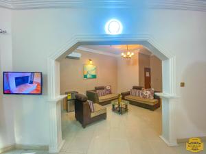 a living room with couches and a clock on the wall at MJ Grand Hotel in East Legon