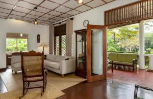 uma sala de estar com um sofá e uma cadeira em Surveyor's Residence Bungalow em Kandy