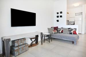 a living room with a fireplace and a tv on the wall at Tiramisu for two by HolyGuest in Tel Aviv