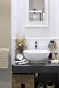 La salle de bains est pourvue d'un lavabo blanc et d'un miroir. dans l'établissement Appartement d'architecte - Puteaux Centre, à Puteaux