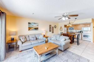 uma sala de estar com um sofá e uma mesa em Sea Breeze 705 em St. Pete Beach