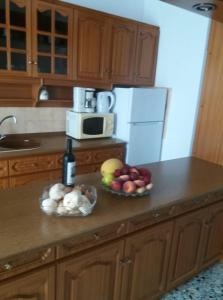 a kitchen with a bowl of fruit and a bottle of wine at Eleni House in Néa Péramos