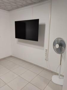 Zimmer mit einem Flachbild-TV an der Wand in der Unterkunft La Bell'appart Ibis rouge in Sinnamary