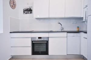 a white kitchen with a sink and a stove at Tiramisu for two by HolyGuest in Tel Aviv