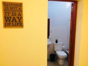 a bathroom with a toilet and a sign on the wall at Complejo Nazareno in San Juan