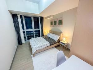 ein kleines Schlafzimmer mit einem Bett und einem Fenster in der Unterkunft A2J BGC Luxury Uptown 2BR Balcony Suite Near Malls in Manila
