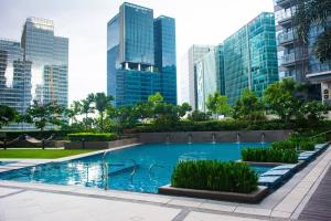 ein Schwimmbad in einer Stadt mit hohen Gebäuden in der Unterkunft A2J BGC Luxury Uptown 2BR Balcony Suite Near Malls in Manila