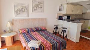 クアルテイラにあるMusa Marのリビングルーム(ベッド1台付)、キッチンが備わります。