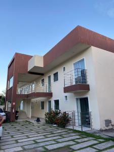 - un bâtiment avec 2 balcons sur le côté dans l'établissement Apartamento 2 quartos a 300m da Praia, à Santa Cruz Cabrália