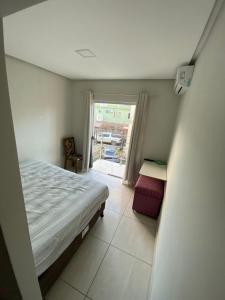 um quarto com uma cama e uma porta de vidro deslizante em Apartamento 2 quartos a 300m da Praia em Santa Cruz Cabrália