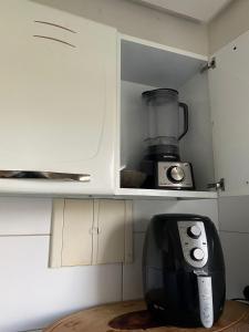 une cuisine avec un mixeur assis sur une étagère dans l'établissement Apartamento 2 quartos a 300m da Praia, à Santa Cruz Cabrália