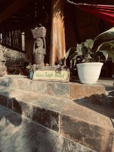 un panneau sur un mur de briques avec quelques plantes dans l'établissement Urbanos Hostel, à Santa Catalina