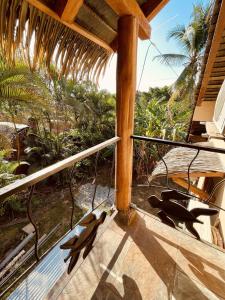 a balcony with a view of the ocean and palm trees at Urbanos Hostel in Santa Catalina