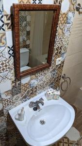y baño con lavabo blanco y espejo. en Apartamento Turístico Monteceli, en Gata