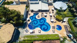 an aerial view of a pool with tables and chairs at Vitoria Regia Praia Hotel in Porto Seguro