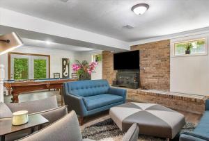 a living room with a blue couch and a pool table at Serenity in the Suburbs: Your Gorgeous RVA Getaway in Richmond